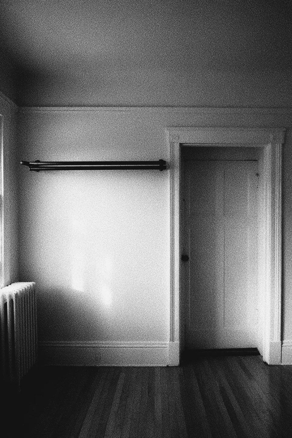 A plain bar fixed across a doorway in an otherwise empty room.